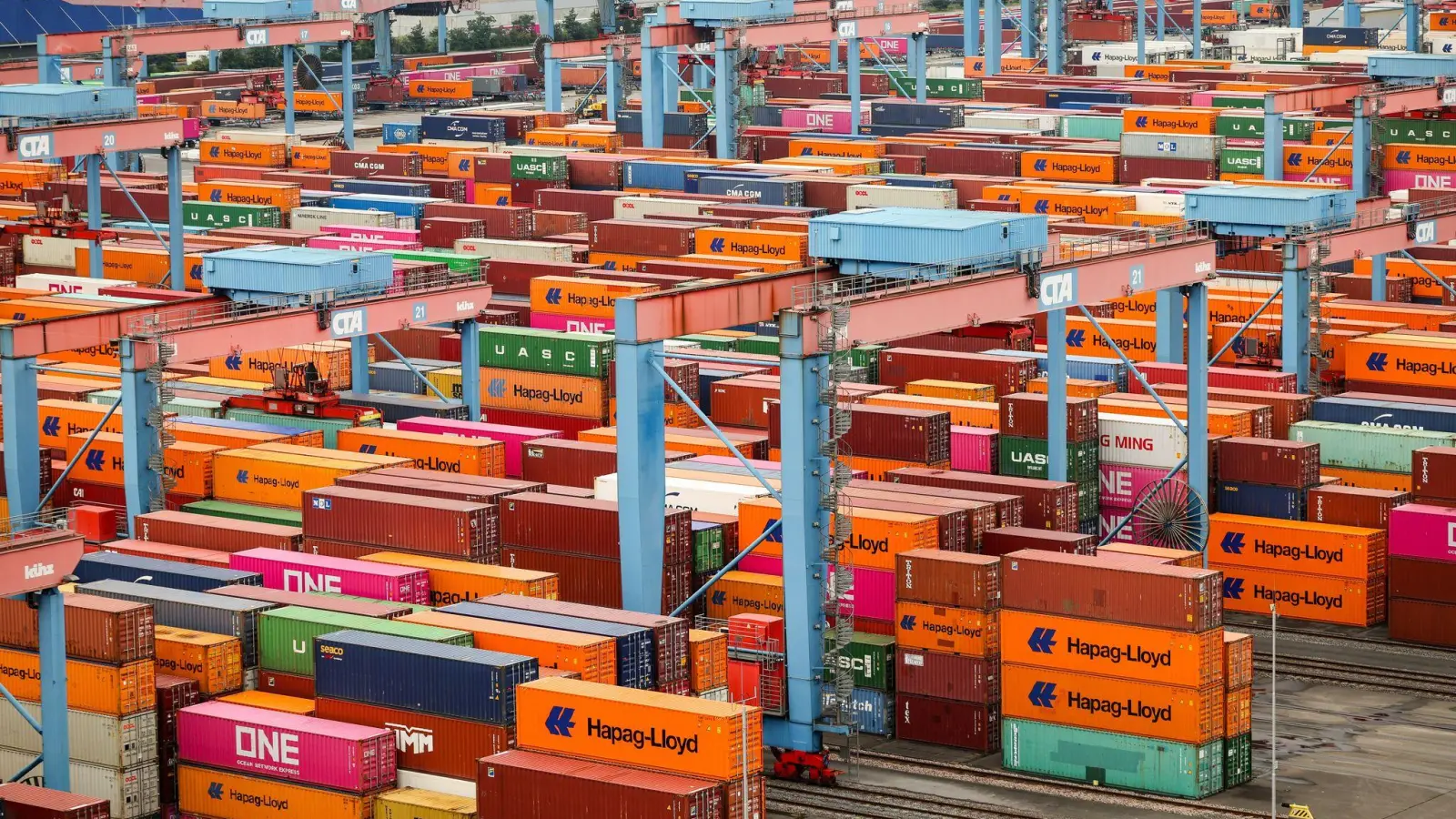 Container vor der Verladung im Hamburger Hafen. Die deutsche Industrie hofft auf Entspannung im Zollkonflikt mit den USA. (Archivbild) (Foto: Christian Charisius/dpa)