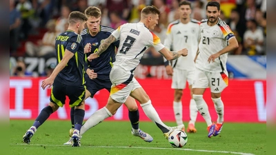 Deutschlands Toni Kroos (M) setzt sich gegen Schottlands Ryan Christie und Scott McTominay durch. (Foto: Christian Charisius/dpa)