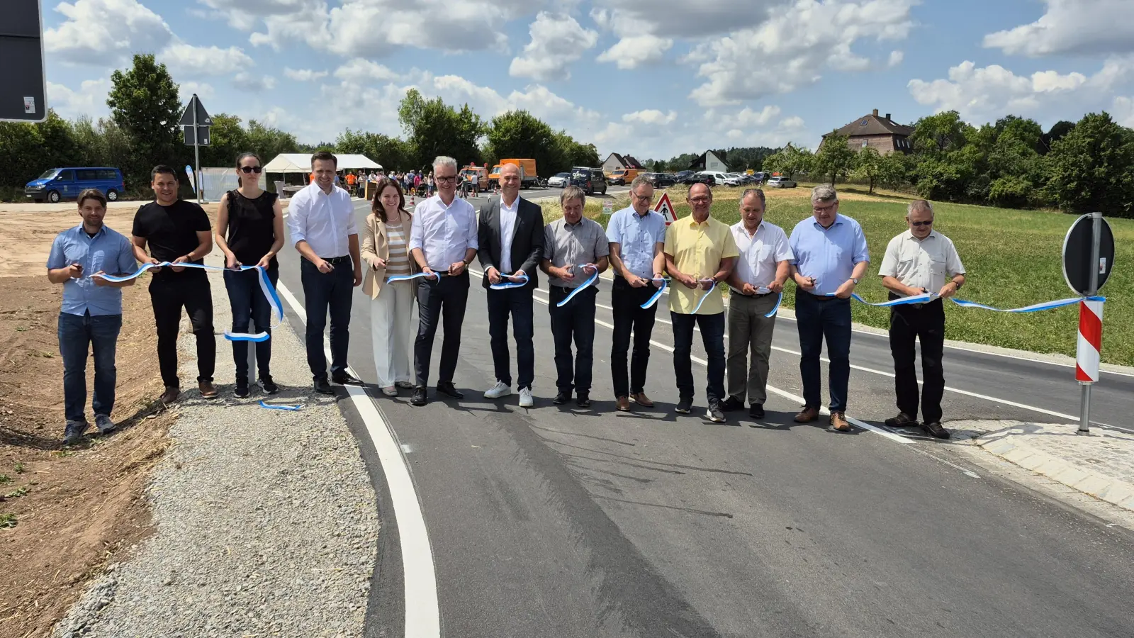 Das symbolische Band ist durchschnitten: Damit gaben Vertreter von Politik, Behörden und Firmen die Umgehung bei Feuchtwangens Ortsteil Sommerau am Freitag auch offiziell frei. Der Verkehr rollt bereits seit Montagnachmittag auf der neuen Straße. (Foto: Peter Zumach)