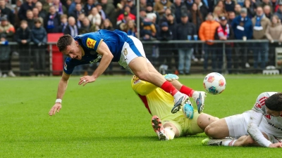 Kiels Adrian Kapralik (l) prallt mit Nürnbergs Jan Reichert zusammen. (Foto: Frank Molter/dpa)