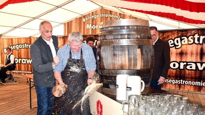 Zum sichtlichen Schreck von Brauereichef Georg Hofmann (links) ließ es Bürgermeister Uwe Emmert bei seiner letzten Pfingstkirchweih-Bierprobe einmal kräftig aus dem 200-Liter-Fass spritzen. (Foto: Gudrun Schwarz)