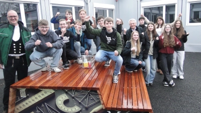 Stolz präsentieren die Schülerinnen und Schüler der 8a Werken Talent der Realschule Heilsbronn ihre Sitzmöbel – hier die Mathematik-Sitzbank. Zimmermeister Marco Roß (links) und Firmenchefin Anja Lederer (3. von rechts) haben ihnen beim Bau geholfen. Mitten im Pulk der Schüler: Lehrerin Anke Schwarz und der stellvertretende Landrat Hans Henninger. (Foto: Winfried Vennemann)