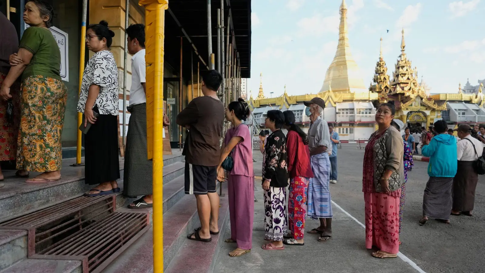 Wähler stellen sich in Yangon, Myanmar, an einem Wahllokal an. (Foto: Thein Zaw/AP/dpa)