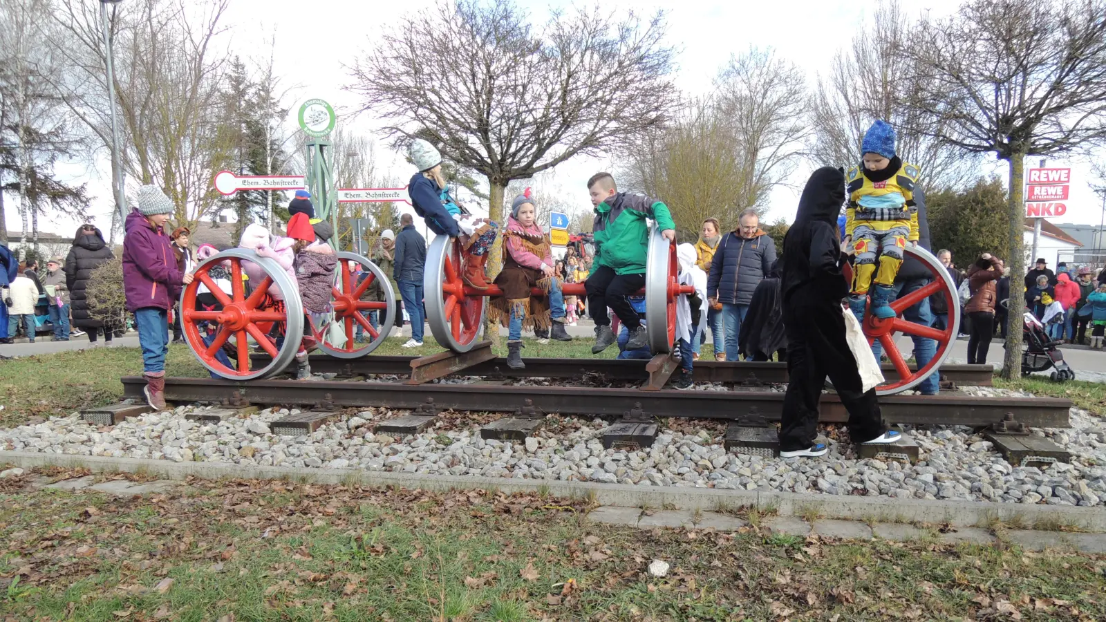 Schon eine halbe Stunde bevor der Umzug startete, standen die Schaulustigen an Herriedens Straßen. Einige Kinder sicherten sich den Logenplatz auf dem Eisenbahn-Denkmal inmitten des Kreisverkehrs. (Foto: Peter Zumach)