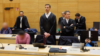 Prozesstart um das Schleusen von Prostituierten aus Thailand nach Deutschland: Die Angeklagten sitzen im Landgericht Bielefeld neben ihren Verteidigern. (Foto: Friso Gentsch/dpa)