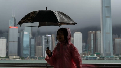 Ein Mädchen hält einen Regenschirm in Tsim Sha Tusi vor dem Victoria Harbor und der Skyline von Hongkong während des Taifuns „Tapah“. (Foto: Vernon Yuen/Nexpher via ZUMA Press Wire/dpa)