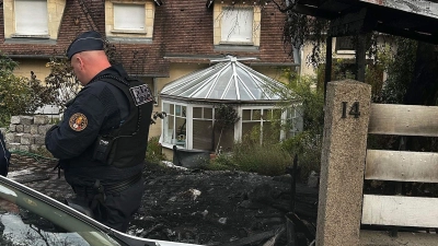 Ein Polizist steht vor dem Haus des Bürgermeisters Vincent Jeanbrun. Randalierer hatten das Haus in der Nacht mit einem Auto gerammt und Feuer gelegt. (Foto: Nassim Gomri/AFP/dpa)