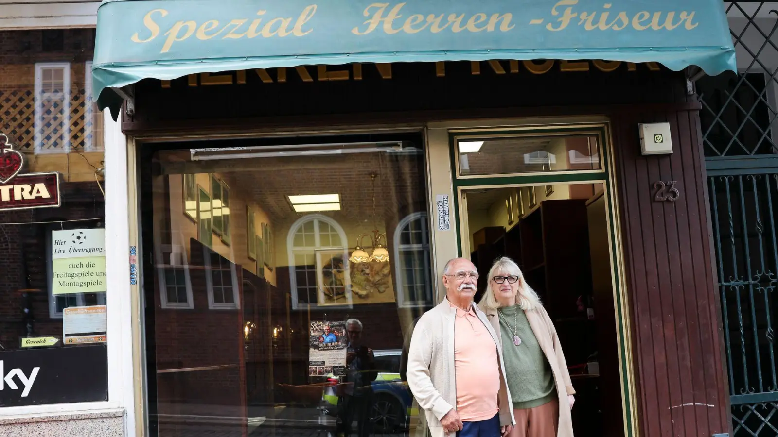 Franz Stenzel und Ute Bickeleit stehen vor dem „Spezial Herren-Friseur“. Schon 1906 gab es in der Davidstraße 23 einen Friseursalon. (Foto: Christian Charisius/dpa)