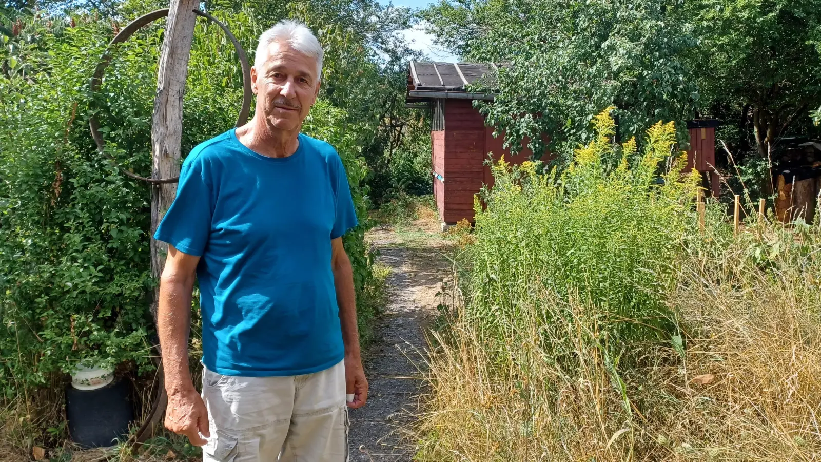 Dietmar Lisson in seinem Garten, hinter ihm das Bienenhaus. Die Imkerei will er trotz des schlimmen Erlebnisses nicht aufgeben. (Foto: Anita Dlugoß)