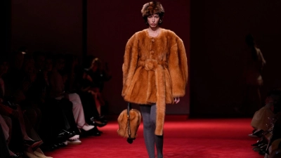 Voluminös und warm: Jacken sind in diesem Winter wahre Blickfänger. Ein opulentes Beispiel: die bernsteinfarbene Jacke mit Gürtel und strukturiertem Kunstfell aus der Bottega Veneta Herbst/Winter 2026-2027 Damenkollektion. (Foto: Luca Bruno/AP/dpa-tmn)