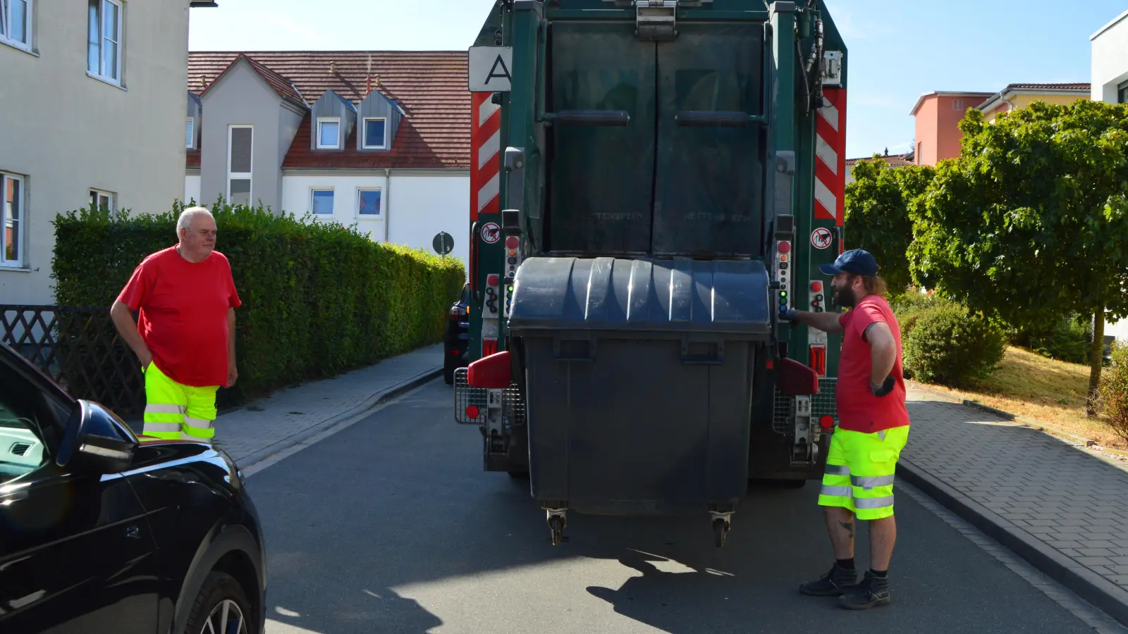 Gemeinsam leeren Fahrer Oliver Götz (links) und Lader Jason Grosche (rechts) die großen Müllcontainer. (Foto: Franz Steinlein)