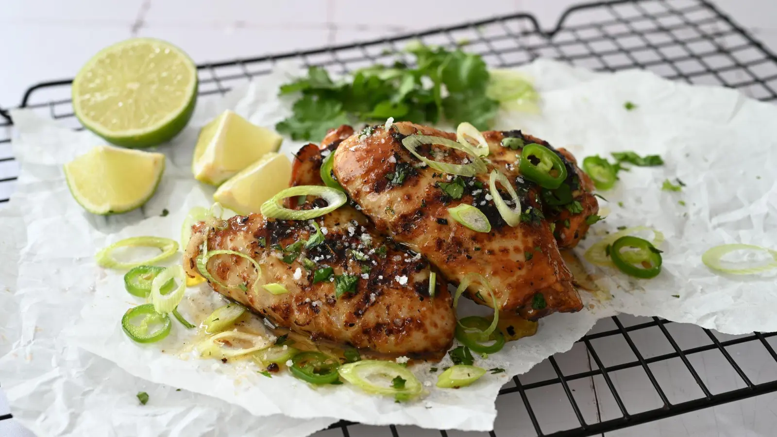 Die würzigen Chicken Wings werden mit Lauchzwiebeln, scharfe grüne Chili und frischer Limettensaft serviert. (Foto: Julia Uehren/loeffelgenuss.de/dpa-tmn)