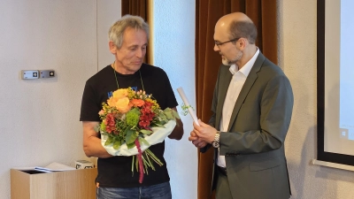 Blumen und ein Restaurant-Gutschein zum Abschied: Manfred Schmaus (links) wurde von Bürgermeister Markus Liebich für seine zehnjährige Tätigkeit im Stadtrat von Leutershausen gewürdigt. (Foto: Wolfgang Grebenhof)