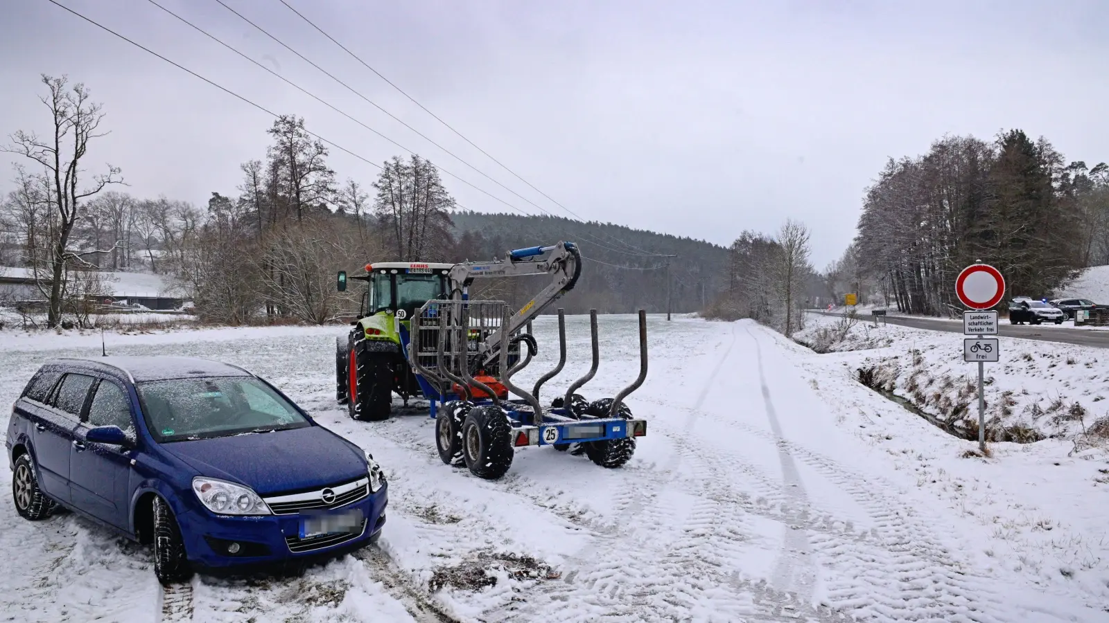 Der Glätteunfall ging glimpflich aus. Das Foto zeigt das beteiligte Traktorgespann und den beschädigten Pkw neben der Straße. (Foto: Jim Albright)