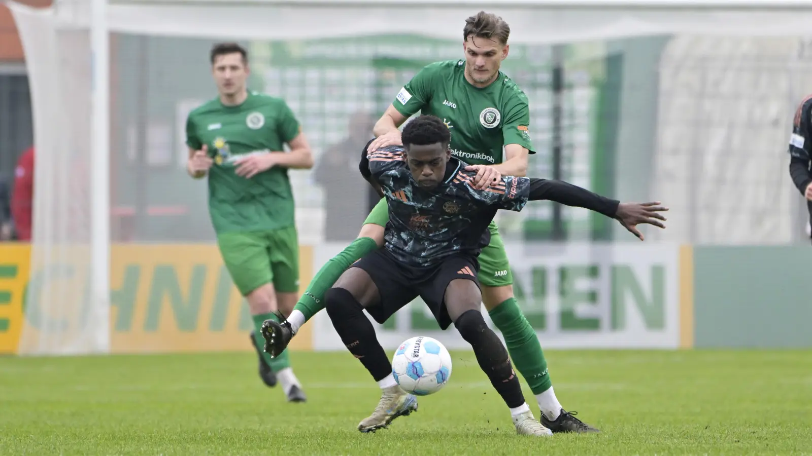 Daniel Schelhorn (grünes Trikot, hier im Zweikampf mit Noel Aseko Nkili vom FC Bayern München II) rückt voraussichtlich in die Ansbacher Startelf. (Foto: Martin Rügner)