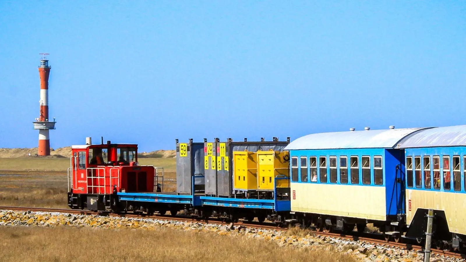Gemächlich fährt Inselbahn über die Salzwiesen von Wangerooge. (Foto: Bernd F. Meier/dpa-tmn)