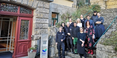 Es herrscht große Verunsicherung im Wildbad-Team, das aktuell aus etwas mehr als 30 Frauen und Männern besteht. Das Foto zeigt zwölf von ihnen – wegen unterschiedlicher Arbeitszeiten je nach Bedarf sind nie alle gleichzeitig da – auf der Treppe neben dem Haupteingang. (Foto: Jürgen Binder)