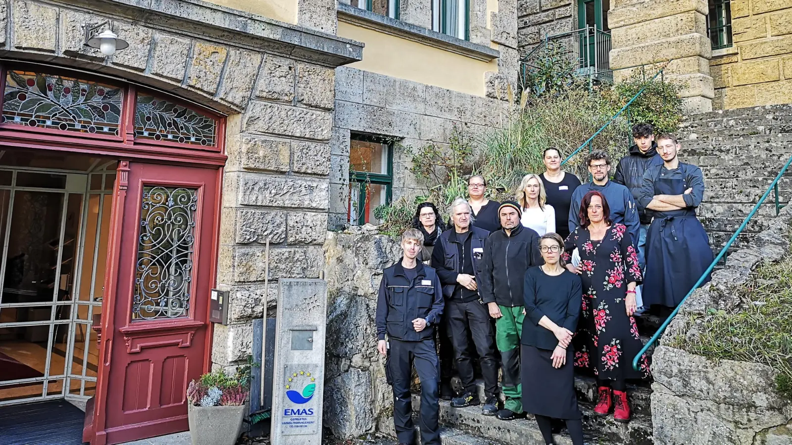 Es herrscht große Verunsicherung im Wildbad-Team, das aktuell aus etwas mehr als 30 Frauen und Männern besteht. Das Foto zeigt zwölf von ihnen – wegen unterschiedlicher Arbeitszeiten je nach Bedarf sind nie alle gleichzeitig da – auf der Treppe neben dem Haupteingang. (Foto: Jürgen Binder)