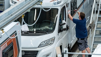 Ein Mann arbeitet an einem Wohnmobil im Werk der Knaus Tabbert AG. (Foto: Armin Weigel/dpa)