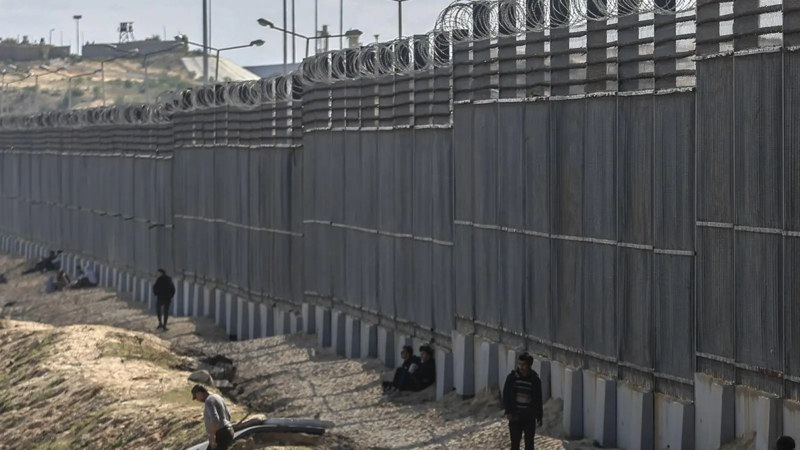 Palästinenser stehen nahe der Grenze zwischen dem Gazastreifen und Ägypten. (Foto: Mohammed Talatene/dpa)