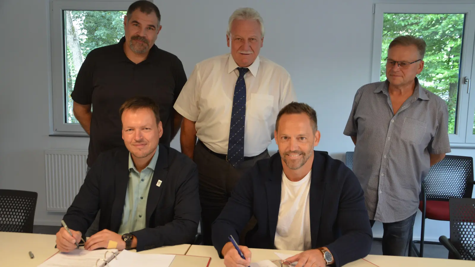 Ingenieur Bernd Ernst, Klaus Meier, der Technische Leiter der Kläranlage, Klaus Heinl (hinten von links stehend) und Markus Helmreich sowie der Leiter der Kommunalbetriebe Neustadt, Christian Hübner (von links vorne) bei der Vertragsunterzeichnung. (Foto: Christa Frühwald)