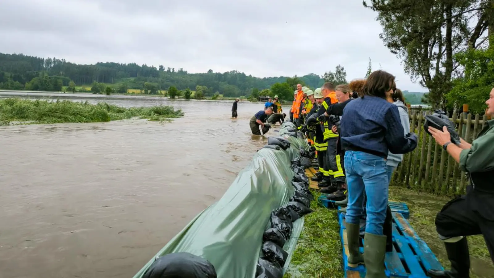 Die Helfer schlichten Sandsäcke an der Schmutter. (Foto: Landratsamt Ansbach/Bernd Wimmer)