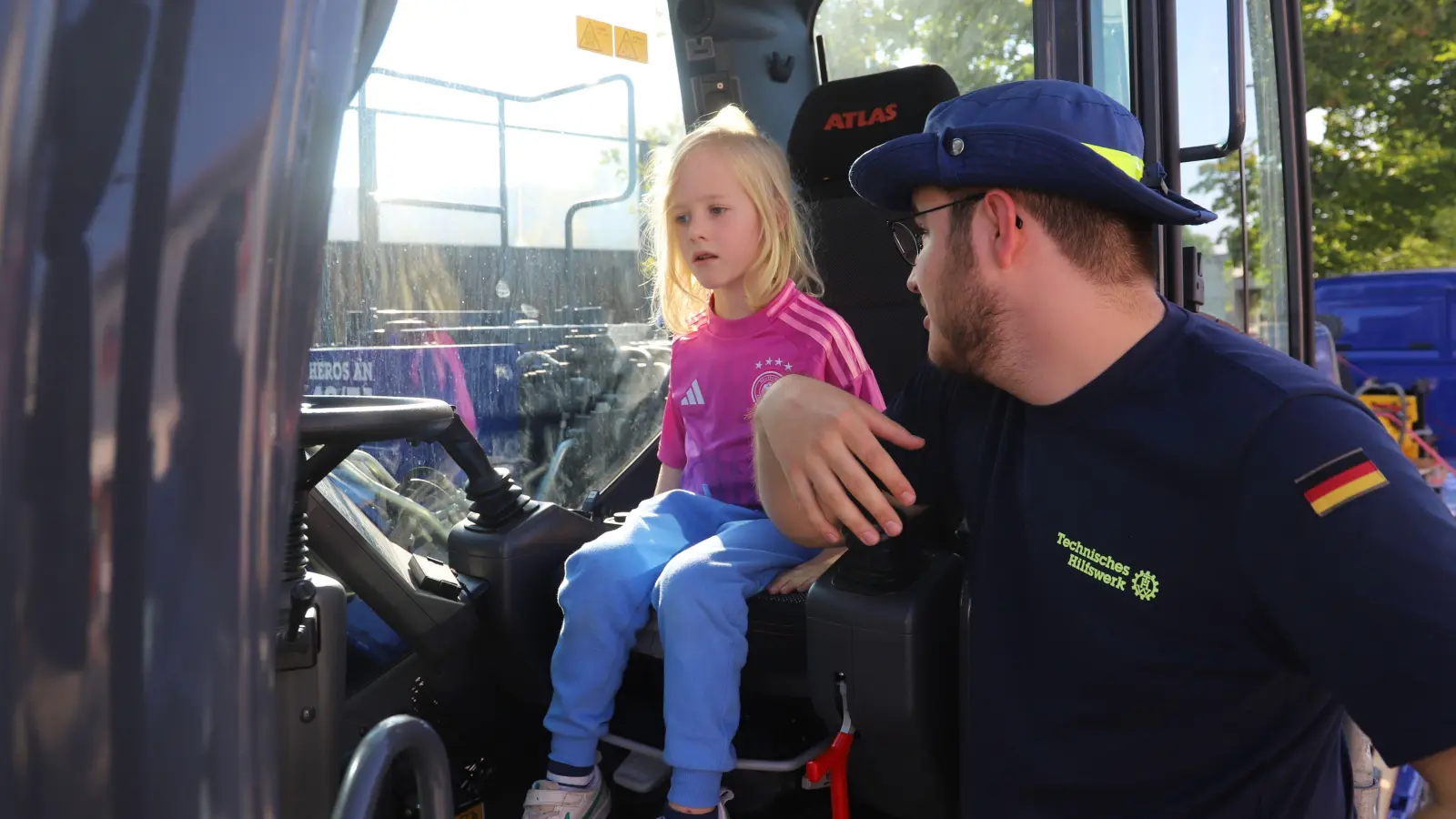 Den Kindern, die im Radbagger des Technischen Hilfswerks (THW) Platz nehmen, hat Helfer Fabrice Bäuchle viel zu erklären. (Foto: Oliver Herbst)