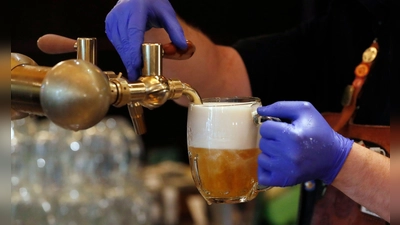 Ein Barkeeper zapft ein Bier auf einer Restaurant-Terrasse. (Symbolbild) (Foto: Petr David Josek/AP/dpa)