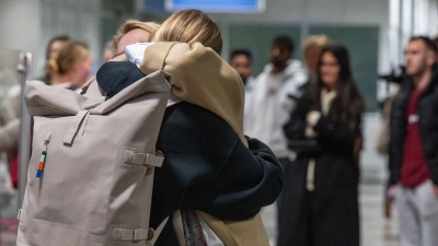 Viele Heimkehrer lagen am Flughafen erleichtert ihren Familien in den Armen. (Foto: Armin Weigel/dpa)