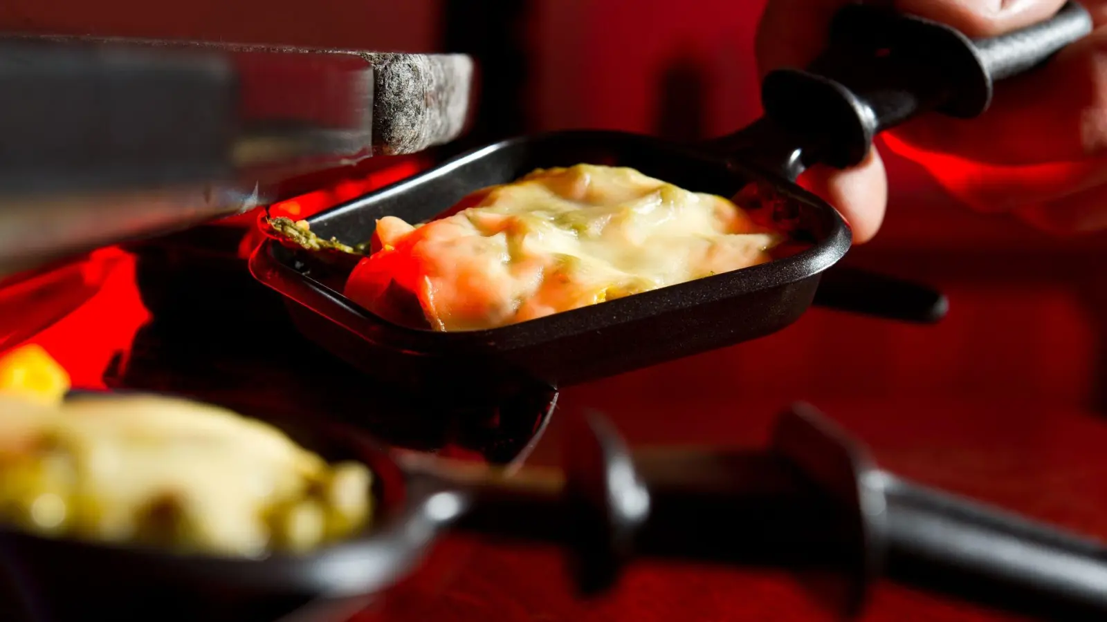 Was brutzelt da? Die Rinde mancher Raclette-Käsesorten sollte man vor dem Erhitzen einen halben Zentimeter abschneiden. (Foto: Franziska Gabbert/dpa-tmn)