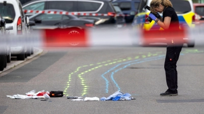 Eine Polizeibeamtin sichert Spuren am Unfallort. (Foto: Christoph Reichwein/dpa)