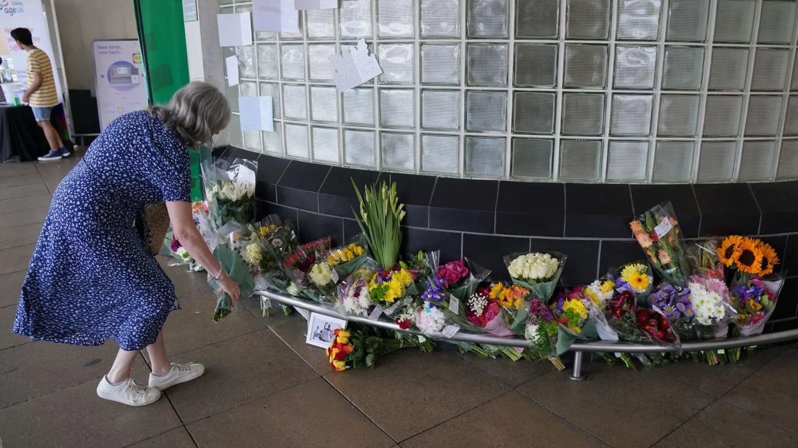 Eine Frau legt Blumen vor dem Perivale Tesco in London ab, wo der 87-jährige Thomas O&#39;Halloran erstochen wurde. (Foto: Jonathan Brady/PA Wire/dpa)