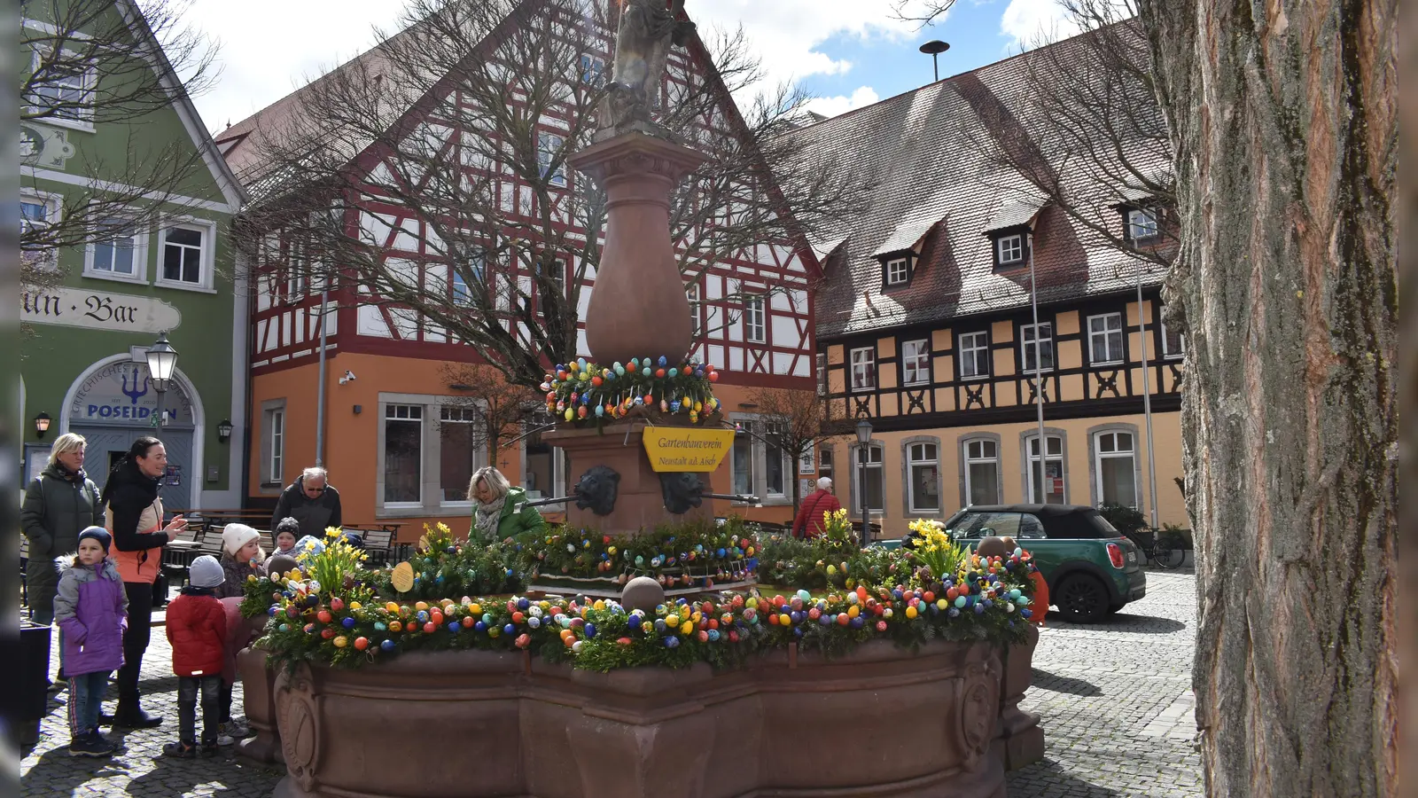 Am Marktplatz in Neustadt/Aisch schmückten die Mitglieder des Obst- und Gartenbauvereins im Beisein vieler Kinder den Neptunbrunnen. (Foto: Ute Niephaus)