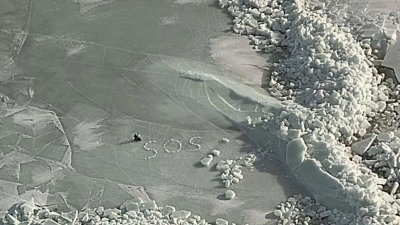 SOS auf dem Eis: Nach dem Einbruch ihres Zeltes ins Eis retten sich zwei Camper mit Mühe und werden nach fünf Stunden per Hubschrauber geborgen. (Foto: Finnish Border Guard/dpa)