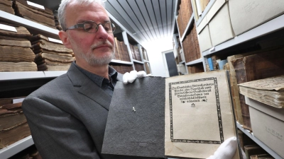 Christoph Engelhard, Stadtarchivar von Memmingen, zeigt im Archiv eine Druckausgabe der „Zwölf Artikel“ aus dem Jahr 1525. (Foto: Karl-Josef Hildenbrand/dpa)