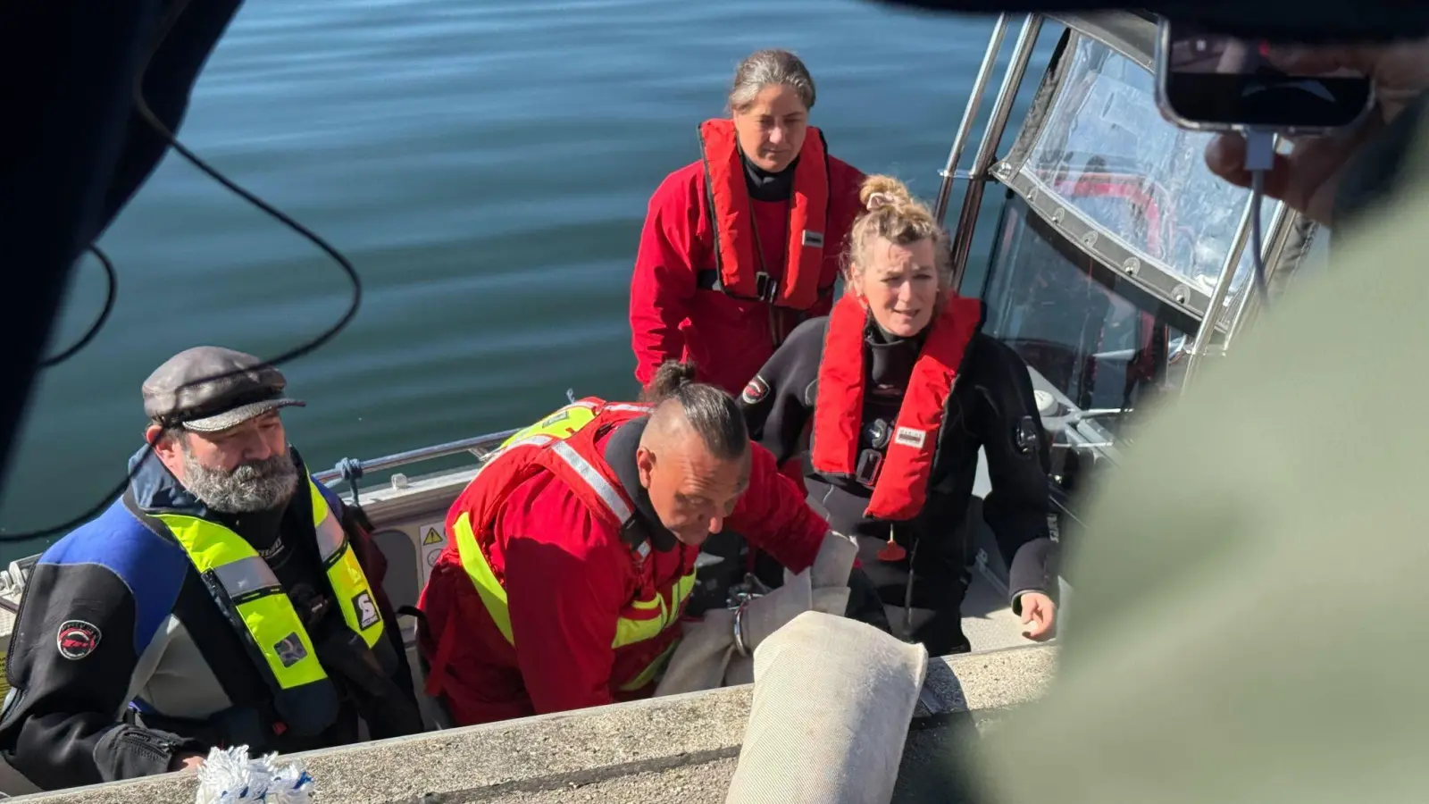 Helfer besteigen ein Boot, um zum Wal hinauszufahren.  (Foto: Helena Dolderer/dpa)
