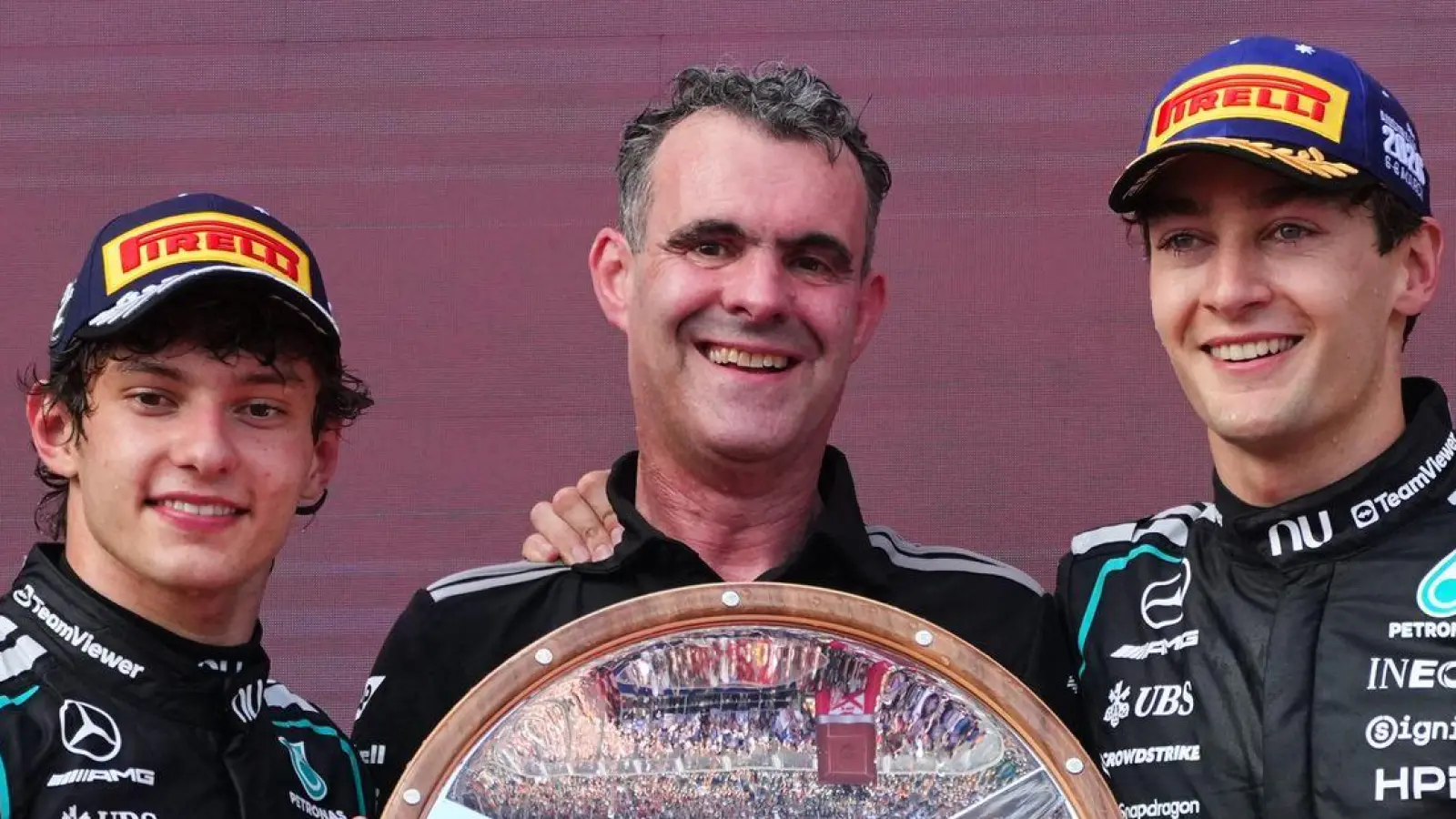 George Russell (r) freut sich über Silbergeschirr. (Foto: Scott Barbour/AP/dpa)