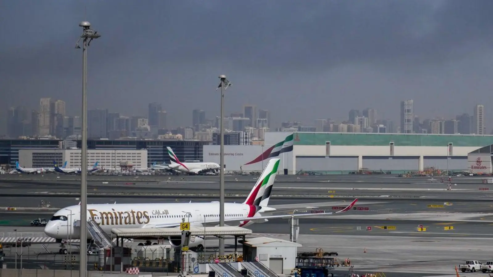 Rauchwolken nahe dem Flughafen von Dubai. In den Vereinigten Arabischen Emiraten saßen infolge des Kriegs im Nahen Osten viele Reisende fest. (Archivbild) (Foto: Altaf Qadri/AP/dpa)
