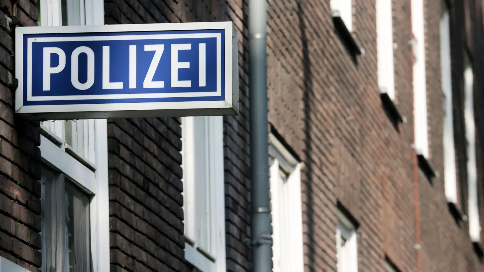 Ein Schild mit der Aufschrift „Polizei“ hängt an einem Polizeipräsidium. (Foto: Roland Weihrauch/dpa/Symbolbild)