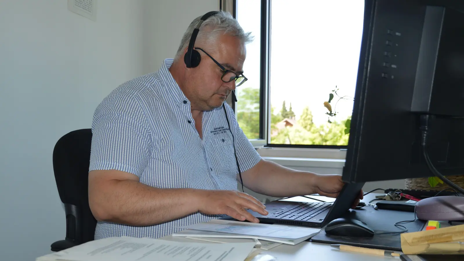 Claus Seifert am Schreibtisch in seinem neuen Büro im Landratsamt. Der Scheinfelder Alt-Bürgermeister will und soll seinen ehemaligen Kollegen dabei helfen, mehr staatliche Fördergelder für ihre Kommunen an Land zu ziehen.  (Foto: Patrick Lauer)