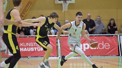 Vier Sekunden vor der Schlussirene traf Raul Dumnici (im weißen Trikot) zum 69:68-Sieg für seine Ansbach Piranhas gegen die TS Jahn München (Pirmin Gaisser). (Foto: Martin Rügner)