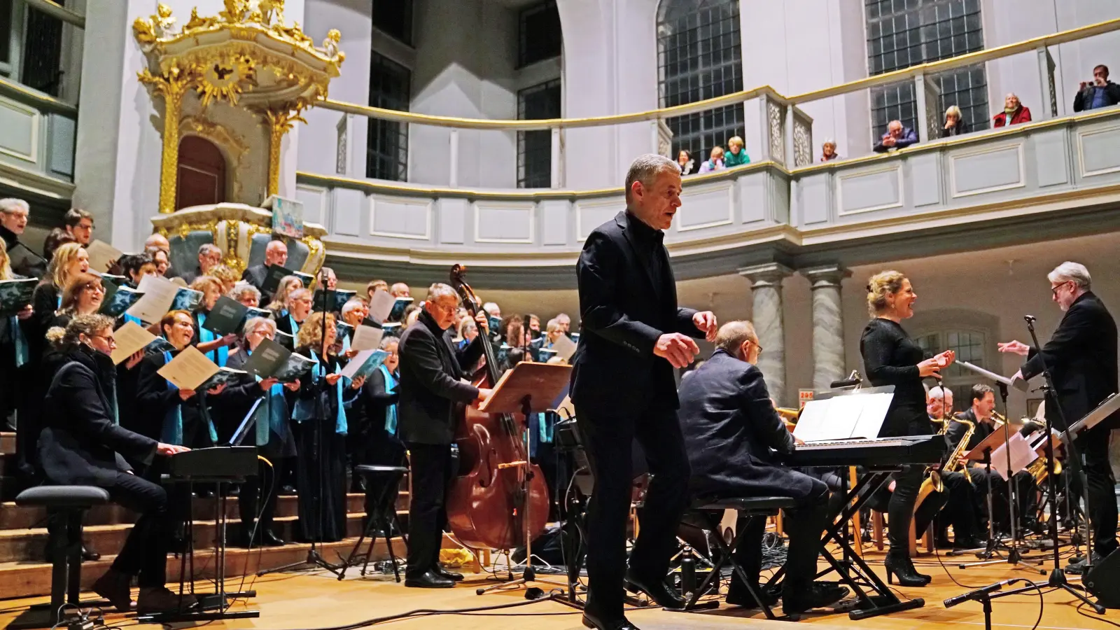 Hoch die Beine: Stepdancer Klaus Bleis (vorne Mitte) gibt dem Sacred Concert in St. Gumbertus eine unkonventionelle Note. Um ihn herum: der Dekanatschor „Come'AN Sing”, die Lehrer Big Band Bayern, die Sängerin Agnes Lepp . Die Leitung hat Kirchenmusikdirektor Carl Friedrich Meyer. (Foto: Elke Walter)