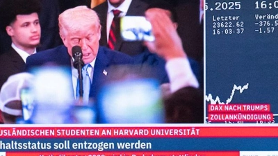 US-Präsident Trump ist auf einem Bildschirm an der Börse in Frankfurt vor der DAX-Kurve zu sehen. (Foto: Boris Roessler/dpa)