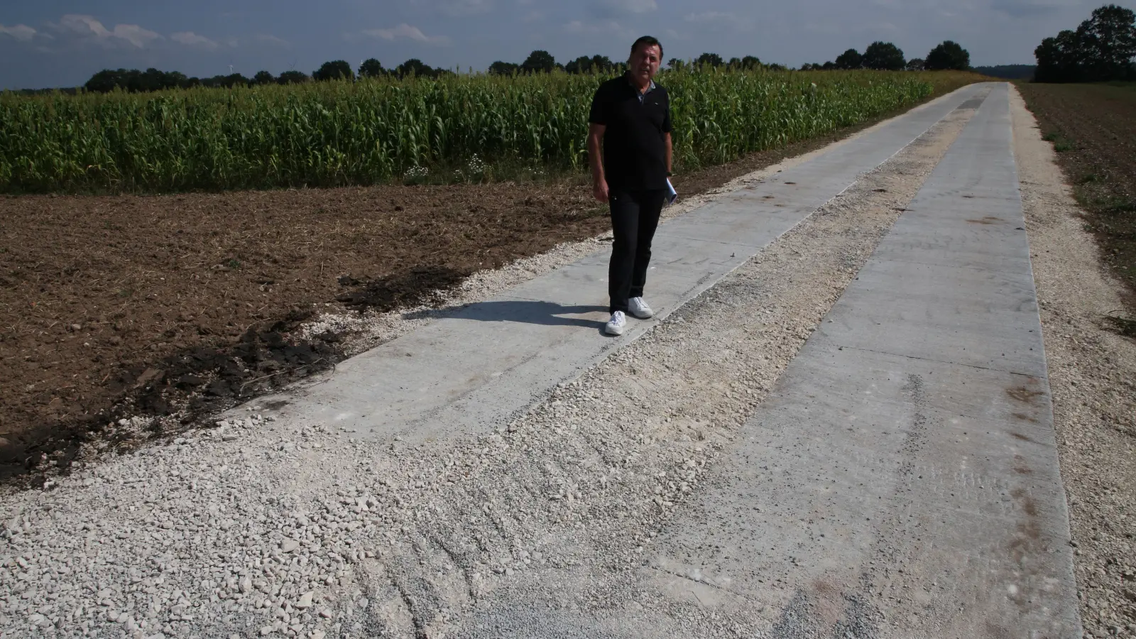 Burgoberbachs Bürgermeister Gerhard Rammler am Übergang des neuen Beton-Spur-Weges auf dem Gebiet der Gemeinde Weidenbach zum einfacher, aber genauso effektiv sanierten Wegabschnitt auf dem Gebiet Burgoberbachs. (Foto: Alexander Biernoth)