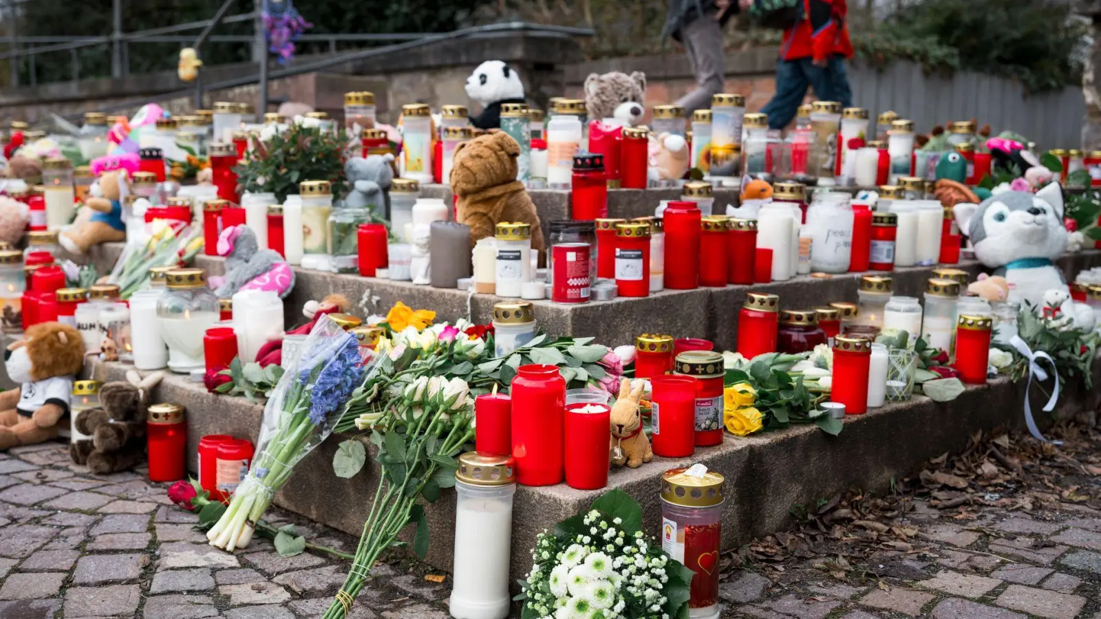 Viele Menschen kommen zum Tatort und legen Blumen und Kerzen ab. (Foto: Daniel Vogl/dpa)