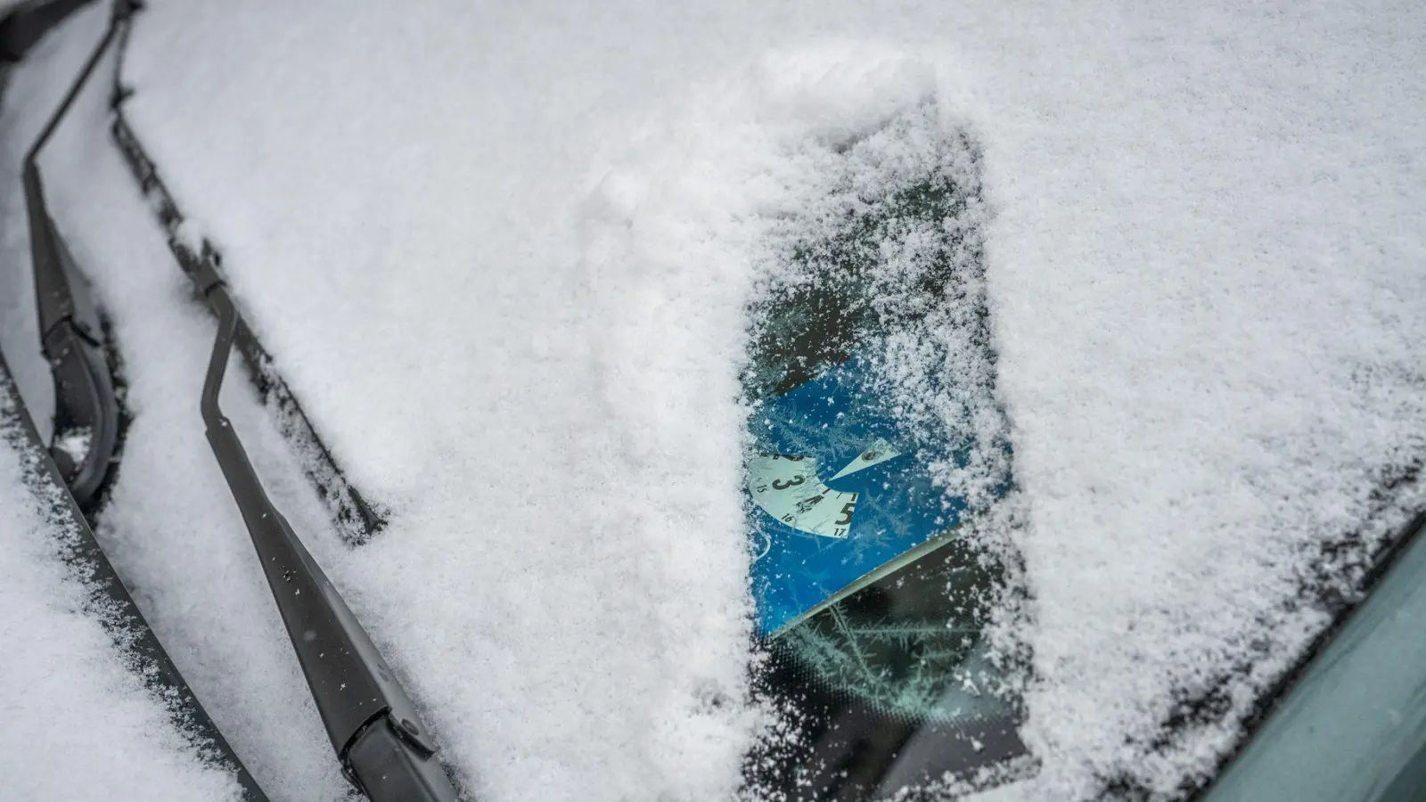 Parkscheine und Anwohnerausweise müssen grundsätzlich gut sichtbar im Auto liegen: Nachträglich durch Schnee oder Eis verdeckte Dokumente führen jedoch nicht zu einem Knöllchen, solange sie gültig sind. (Foto: Zacharie Scheurer/dpa-tmn)