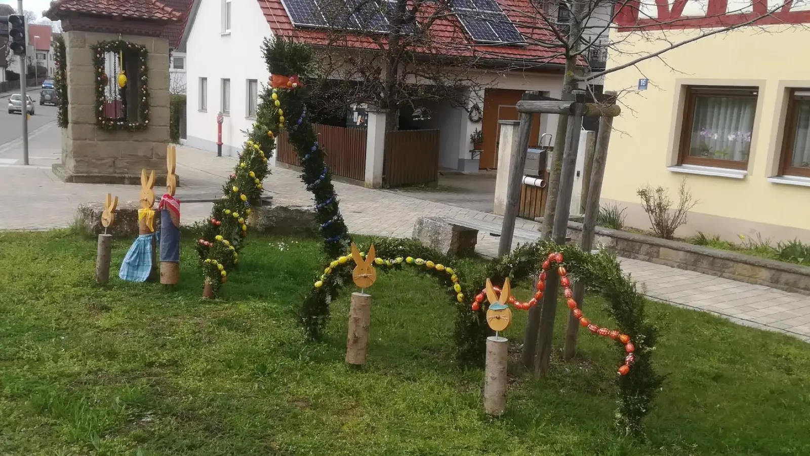 Schlicht mit bunten Eiern und mehreren Holz-Häschen ist der Brunnen in Dottenheim verziert. (Foto: Carmen Thoma)