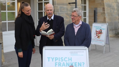 Der Dialektautor Dr. Karl-Heinz Röhlin (Mitte) ist zu Besuch in der Landesausstellung „Typisch Franken?“. Hier unterhält er sich mit Stephanie Santl, Projektmitarbeiterin am Haus der Bayerischen Geschichte und Mitglied im Team der Ausstellungsleitung, und Dietmar Weiß, Mitglied im Koordinationsteam der Schau. (Foto: Oliver Herbst)