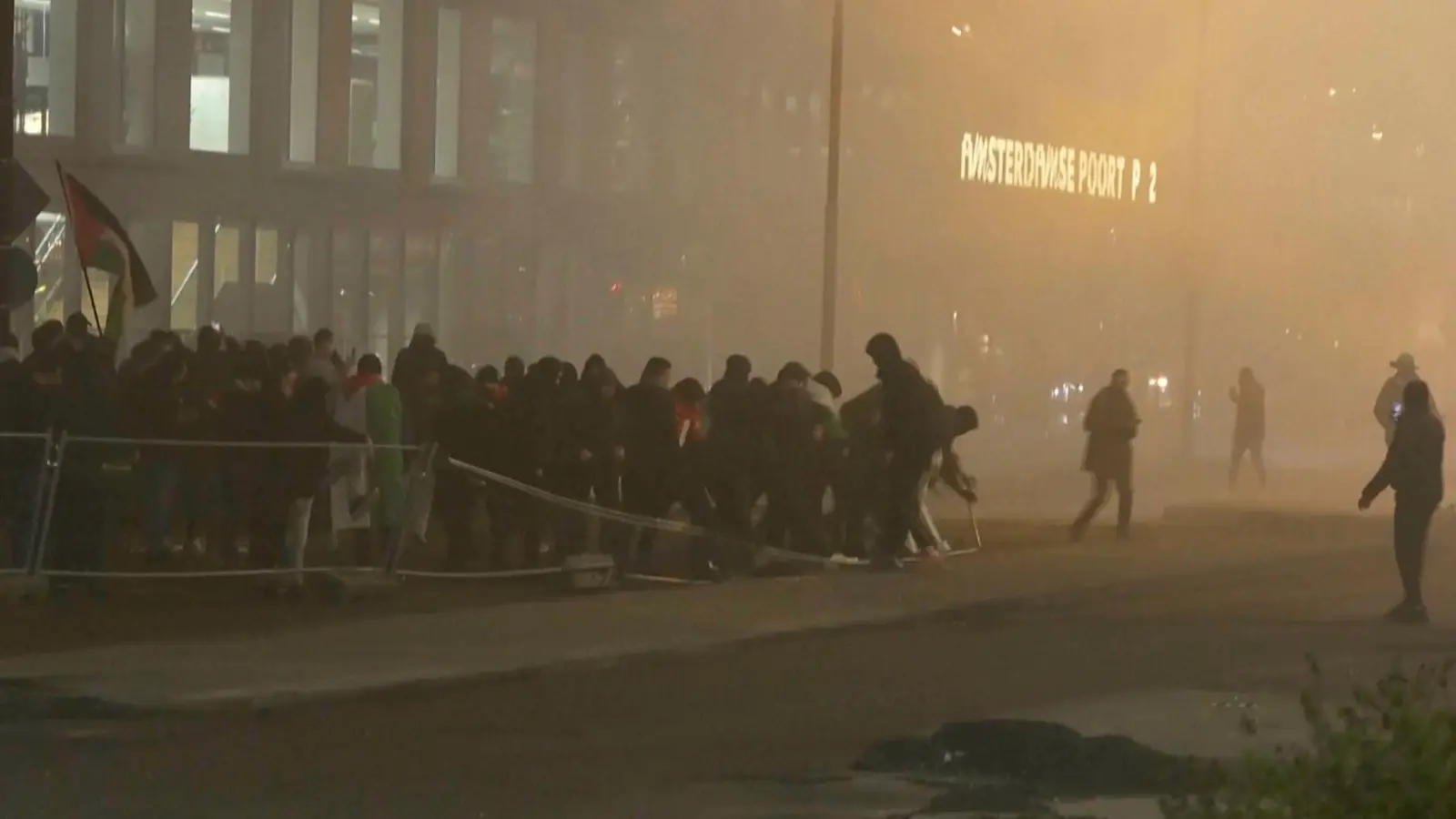 In diesem Videostandbild werfen pro-palästinensische Demonstranten eine Metallbarriere in der Nähe des Fußballstadions in Amsterdam um. (Archiv) (Foto: RTL Nieuws/RTL Nieuws/AP/dpa)