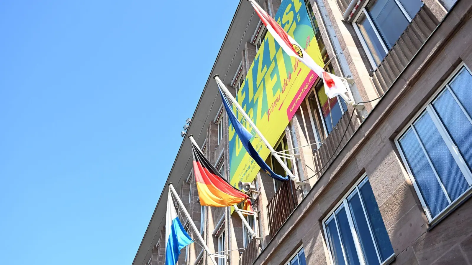 Ein Banner mit der Aufschrift „Jetzt ist die Zeit” prangt an der Fassade des Nürnberger Rathauses am Hauptmarkt. (Foto: Pia Bayer/dpa)